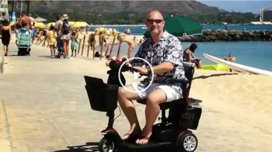 Video: traveler riding a mobility scooter along a Waikiki beach path